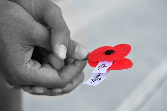 Anzac Commemorations - France and Belgium, Poppy in hands at Arras Memorial Cemetery. Image credit: NZDF Anzac Commemorations - France and Belgium, Poppy in hands at Arras Memorial Cemetery