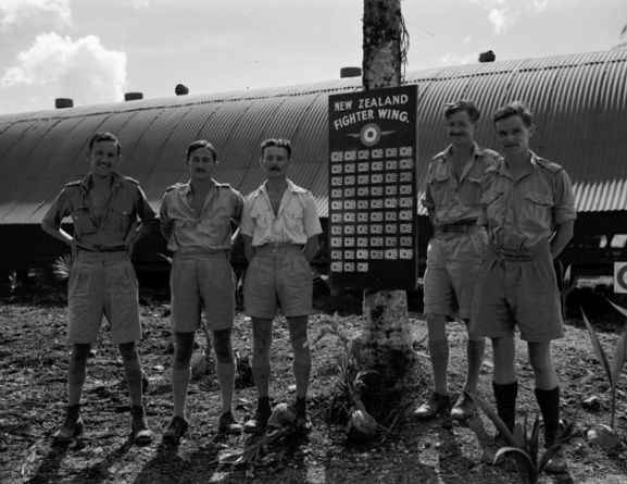 PR2367 copy_web Group of Number 18 Squadron RNZAF officers with the New Zealand Fighter Wing scoreboard, Ondonga, New Georgia, November 1943. Image ref PR2367 ©RNZAF Official.