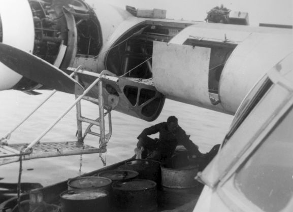 PR2183-R1-15-59 Salvage of Maritime Operational Conversion Unit Sunderland, NZ4111, after it was holed and sank in Te Whanga Lagoon, Chatham Islands. A member of the salvage party draining fuel into drums.