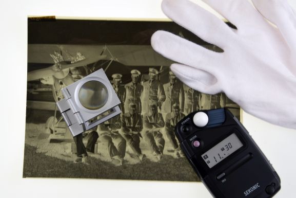 MUS2000110 Still life featuring a negative, light meter, gloves and a magnifier. Air Force museum of New Zealand.