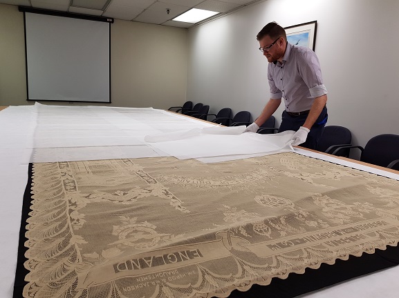 Jason and Battle of Britain lace panel Collections Technician Jason Sim carefully preparing to put the Battle of Britain lace panel back into storage at the Air Force Museum of New Zealand.