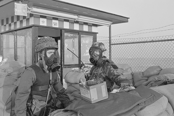 PD15-9-91 RNZAF Flight Lieutenant Ken Cunningham (right) and a soldier wearing gas masks at a guard post during a Scud missile alert at King Khalid International Airport, Riyadh, Saudi Arabia. Feb-Mar 1991. Image ref PD15-9-91, RNZAF Official.