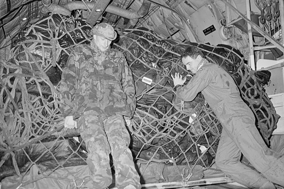 PD18-24-91 Operation Fresco. Flight Sergeant Stephen Skudder (right) and SSE Fred Bias (RAF) loading freight into the back of a No. 40 Squadron Hercules at King Khalid International Airport, Riyadh, Saudi Arabia. Feb-Mar 1991. Image ref PD18-24-91, RNZAF Official.