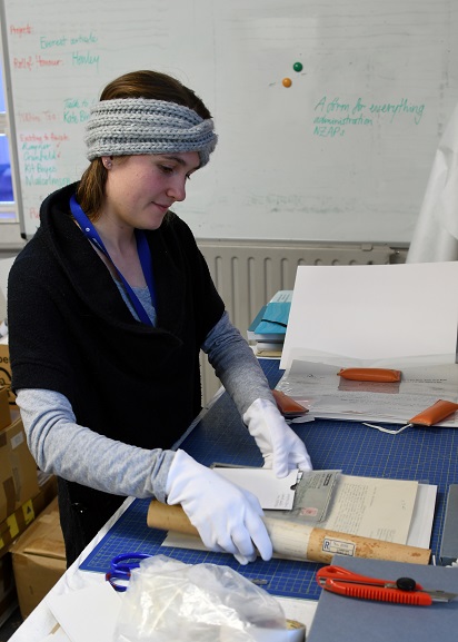 MUS21109 Archives Technician, Louisa Hormann, packing a collection of papers at the Air Force Museum of New Zealand. Image ref MUS21109, Air Force Museum of New Zealand.