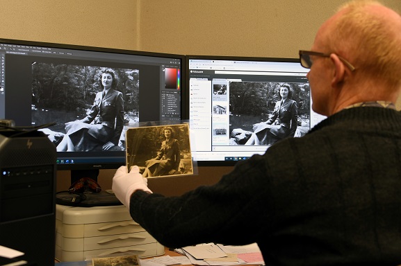 MUS21110 Keeper of Photograph, Matthew O'Sullivan, digitising a photograph in the archives at the Air Force Museum of Zealand. Image ref MUS21110, Air Force Museum of New Zealand.